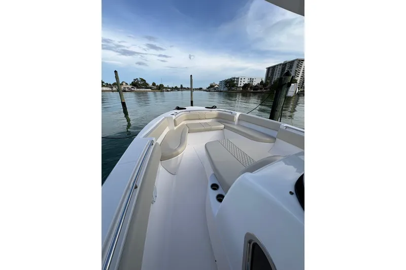 Slide: The Image of 2015 Belzona 32 Cuddy boat interior with seating, docked in a calm marina. - 8