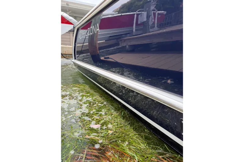 Slide: The Image of 2015 Belzona 32 Center Console boat docked, reflecting water and surroundings. - 4