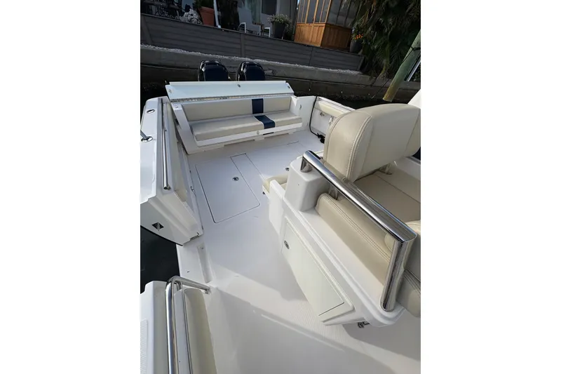 Slide: The Image of 2015 Belzona 32 Center Console boat interior with beige seating and stainless steel railings. - 12