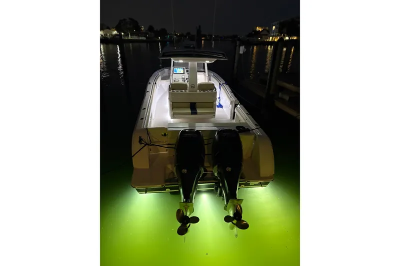 Slide: The Image of 2015 Belzona 32 Center Console boat illuminated at night with underwater lights. - 11