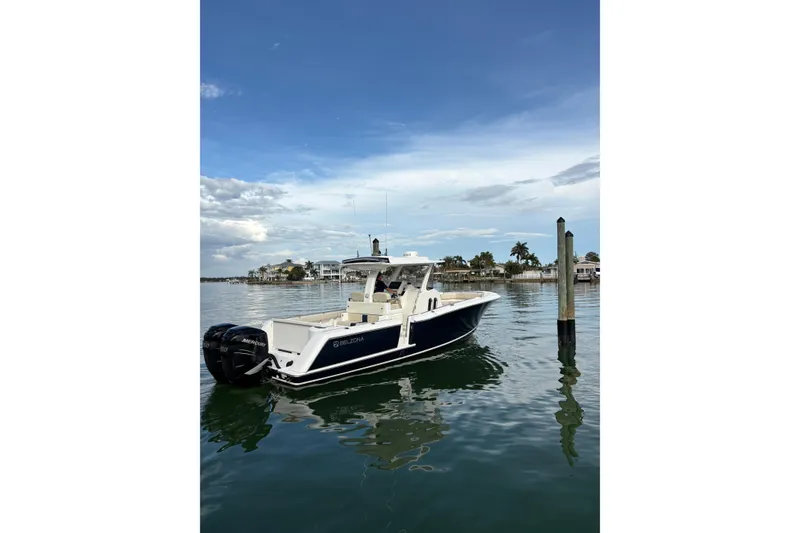 The Image of 2015 Belzona 32 Center Console boat on calm water, with scenic coastal background. - 0