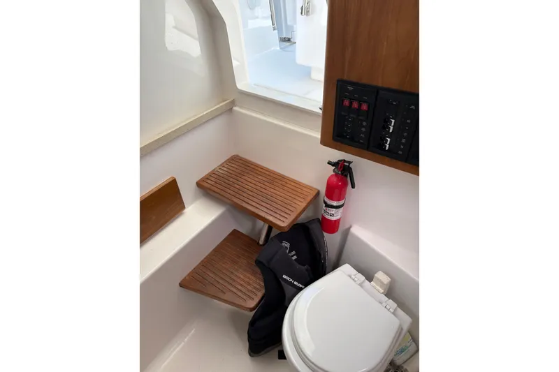 Slide: The Image of Interior of 2015 Belzona 32 Center Console boat with wooden seating, fire extinguisher, and control panel. - 5