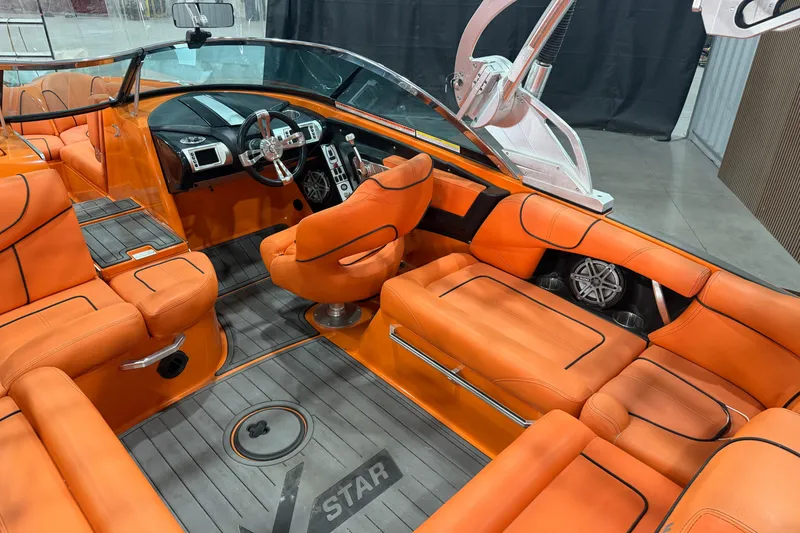 Slide: The Image of 2013 MasterCraft XStar boat interior with vibrant orange seating and modern dashboard design. - 7
