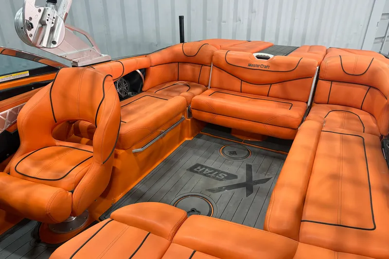 Slide: The Image of 2013 MasterCraft XStar boat interior with vibrant orange seating and sleek design. - 12