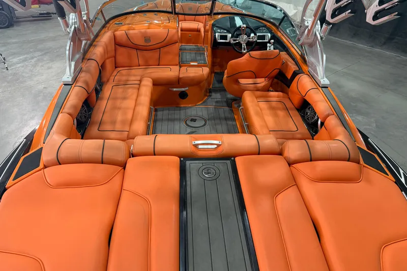 Slide: The Image of 2013 MasterCraft XStar boat interior with vibrant orange seating and sleek design. - 6
