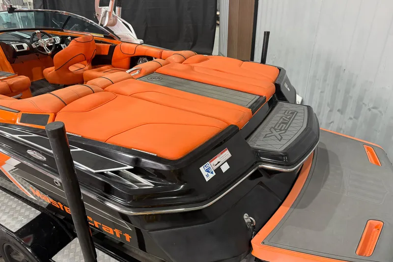 Slide: The Image of 2013 MasterCraft XStar boat with orange seating and sleek black exterior design. - 5