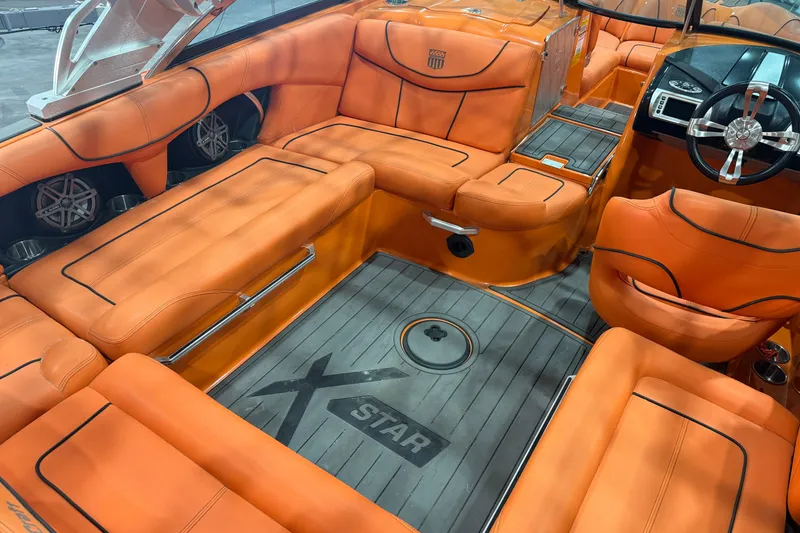 Slide: The Image of 2013 MasterCraft XStar boat interior with orange seating and sleek design. - 8