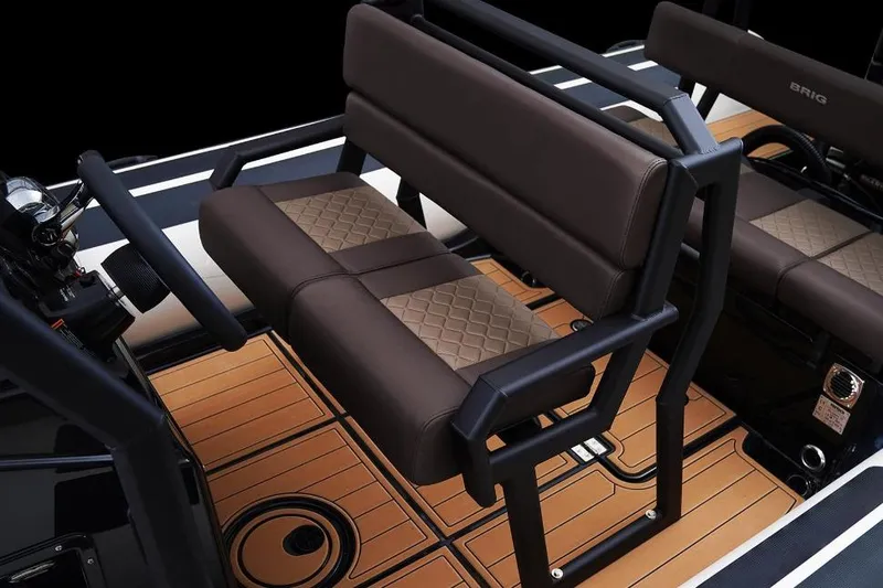 Slide: The Image of 2027 Brig Navigator 22 interior with brown cushioned seating and wood-patterned flooring. - 12