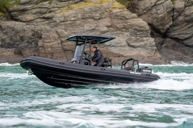 Slide: The Image of Manufacturer Provided Image: 2026 Brig Navigator 22 boat navigating rocky coastal waters. - 2