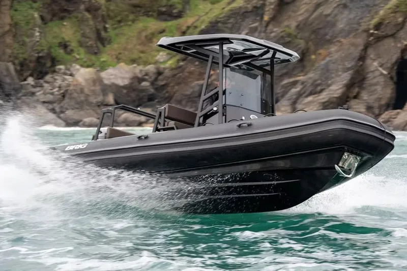 The Image of Manufacturer Provided Image: 2026 Brig Navigator 22 boat navigating through waves near rocky coastline. - 1