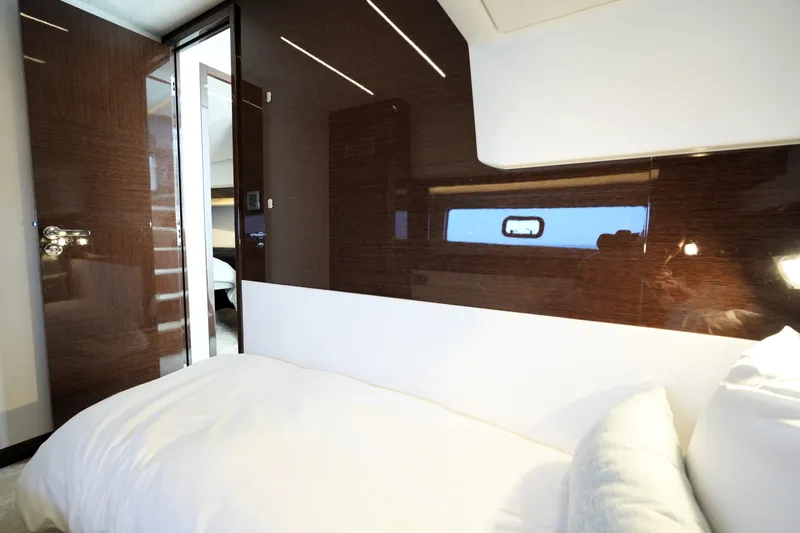 Slide: The Image of Luxurious interior of 2023 Prestige 590 yacht with sleek wood paneling and cozy bedding. - 75