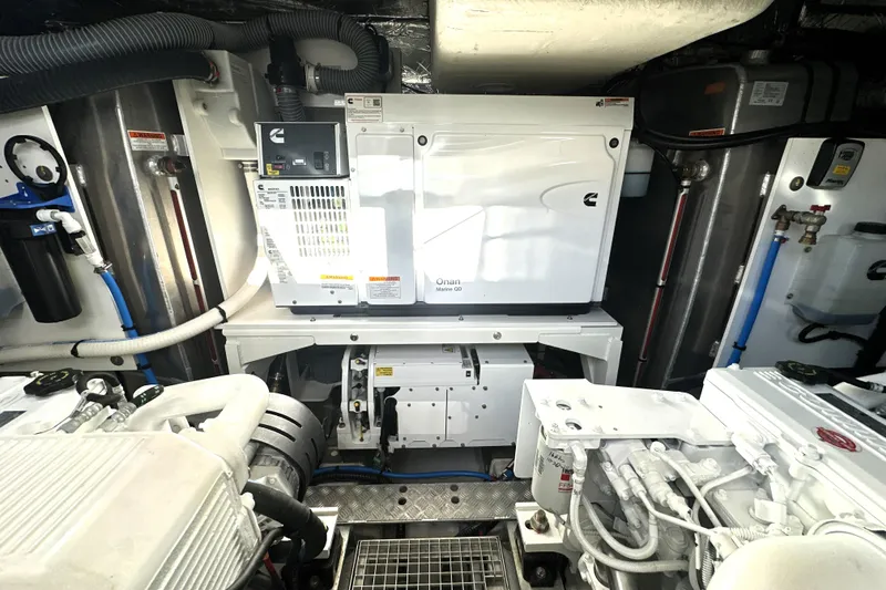 Slide: The Image of Engine room of a 2023 Prestige 590 yacht featuring a Cummins Onan generator. - 88