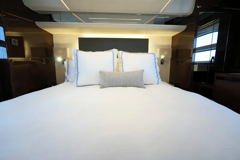 Slide: The Image of Luxurious bedroom interior on a 2023 Prestige 590 yacht, featuring elegant bedding and modern lighting. - 80