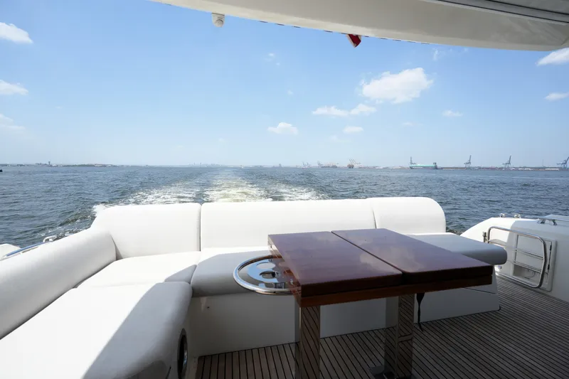 Slide: The Image of Luxury yacht Prestige 590 cruising on open water, featuring elegant seating and table, 2023 model. - 20