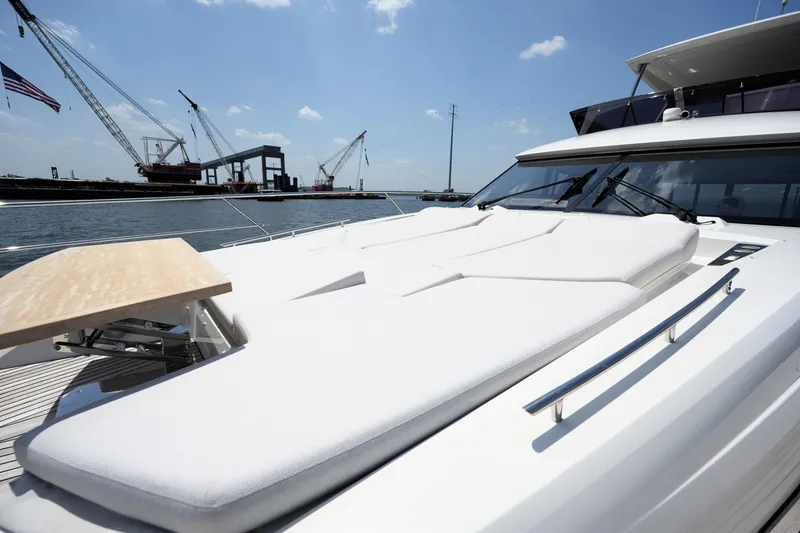 Slide: The Image of Luxurious 2023 Prestige 590 yacht with sunbathing deck, docked near cranes under blue sky. - 30