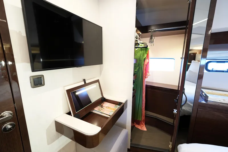 Slide: The Image of Luxurious interior of 2023 Prestige 590 yacht with TV, closet, and elegant furnishings. - 69