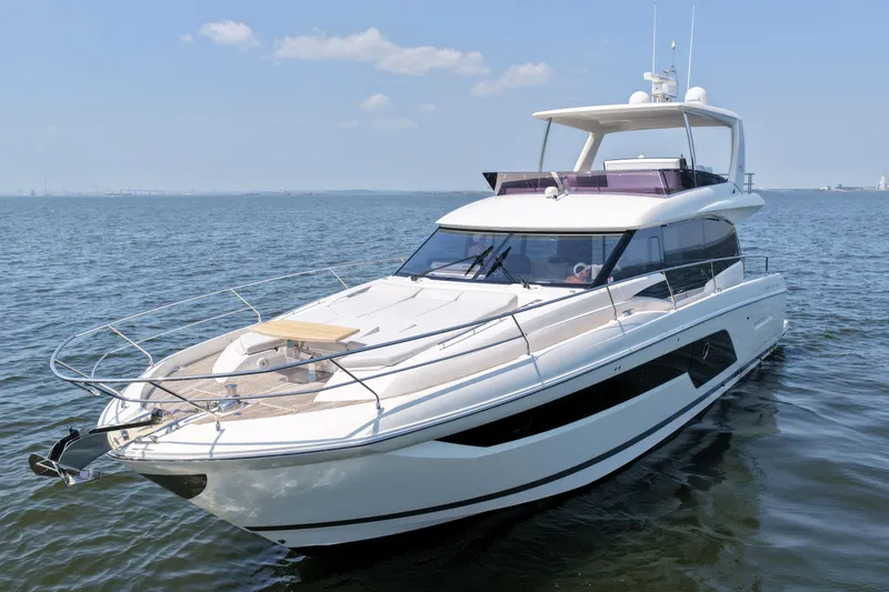 Slide: The Image of Luxury 2023 Prestige 590 yacht cruising on open water under clear skies. - 6