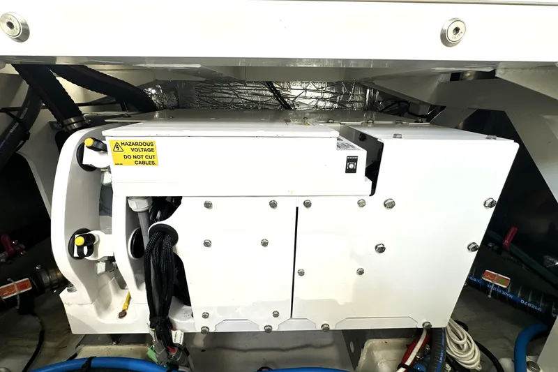 Slide: The Image of Engine compartment of a 2023 Prestige 590 yacht, featuring electrical components and warning label. - 94