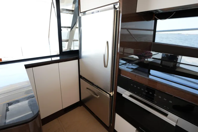 Slide: The Image of Modern kitchen interior on 2023 Prestige 590 yacht, featuring sleek appliances and ocean view. - 53