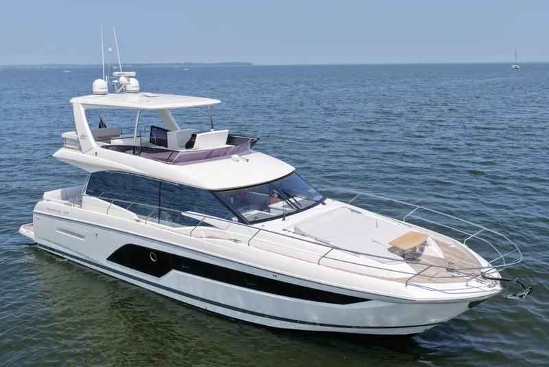Slide: The Image of Luxury 2023 Prestige 590 yacht cruising on open water under clear skies. - 9