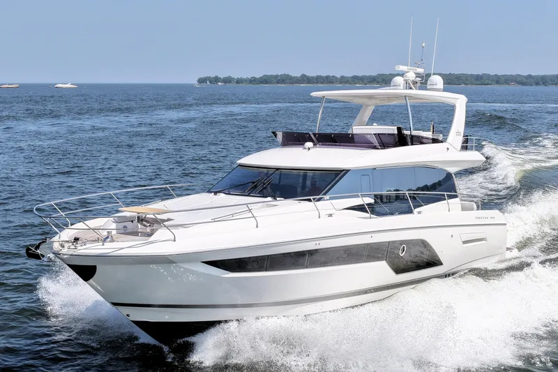 Slide: The Image of Luxurious 2023 Prestige 590 yacht cruising on open water, showcasing sleek design and elegance. - 15