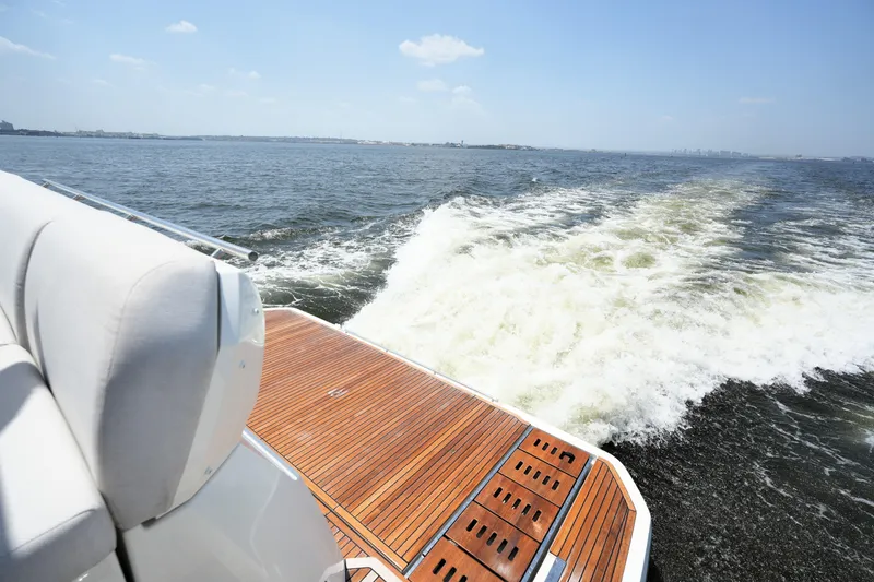 Slide: The Image of Luxury yacht Prestige 590 cruising on open water, showcasing elegant wooden deck, 2023 model. - 17