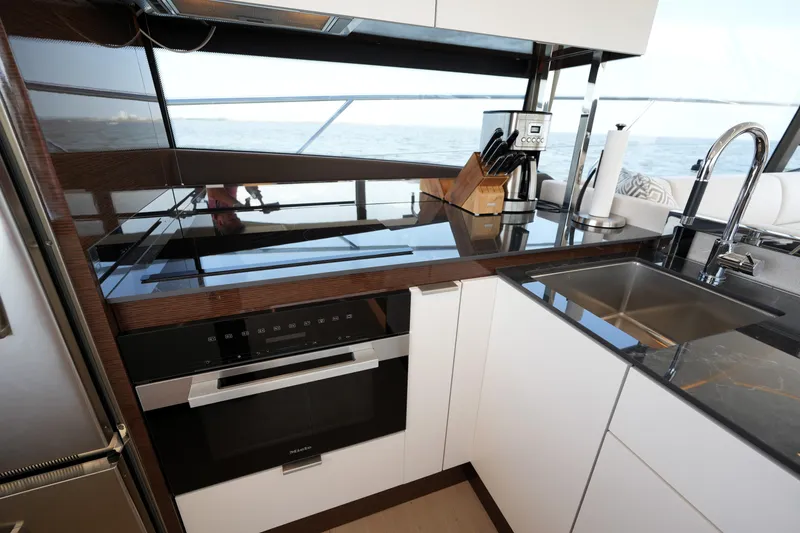 Slide: The Image of Modern kitchen interior on 2023 Prestige 590 yacht, featuring sleek appliances and ocean view. - 50