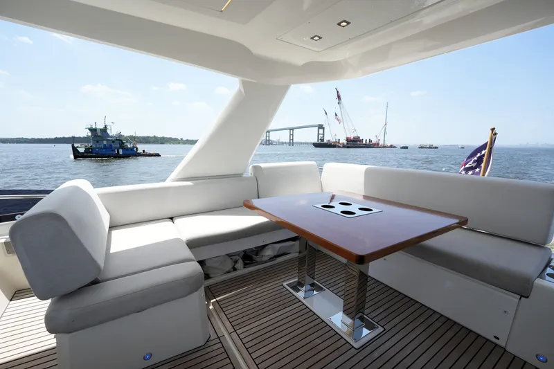 Slide: The Image of Luxurious 2023 Prestige 590 yacht deck with elegant seating and scenic waterfront view. - 32