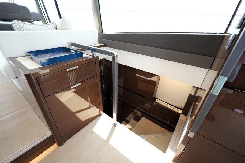 Slide: The Image of Interior of 2023 Prestige 590 yacht, featuring elegant wooden cabinetry and modern design elements. - 77