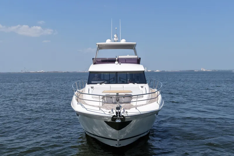 Slide: The Image of Front view of a 2023 Prestige 590 yacht on open water under a clear blue sky. - 7