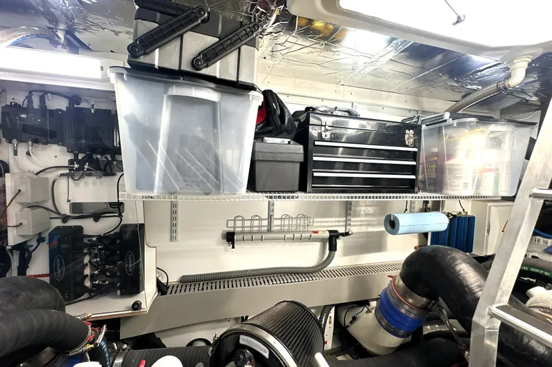 Slide: The Image of Engine room of 2023 Prestige 590 yacht with organized tools and storage containers. - 91