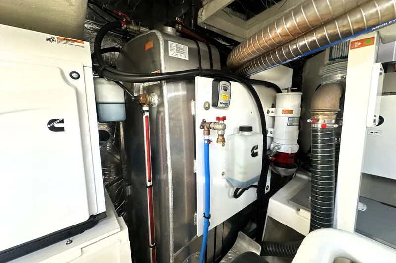 Slide: The Image of Engine room of a 2023 Prestige 590 yacht, featuring Cummins equipment and advanced piping systems. - 93