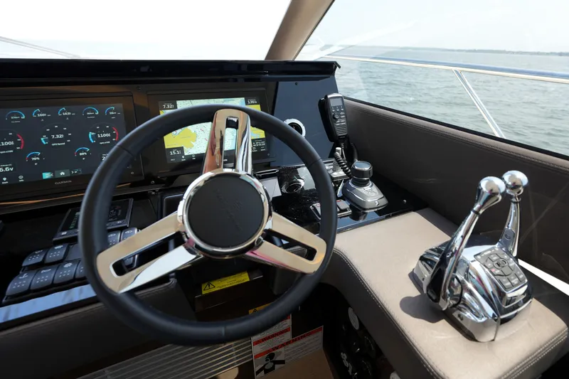 Slide: The Image of Cockpit of 2023 Prestige 590 yacht with steering wheel and navigation controls. - 63