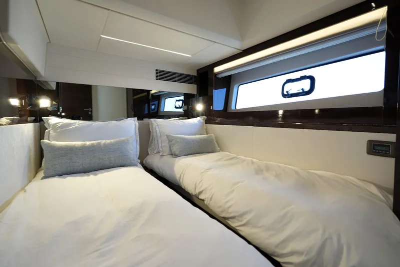 Slide: The Image of Luxurious twin cabin interior on 2023 Prestige 590 yacht, featuring elegant bedding and modern design. - 74