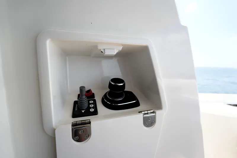 Slide: The Image of Control panel on a 2023 Prestige 590 yacht, featuring joystick and buttons. - 23