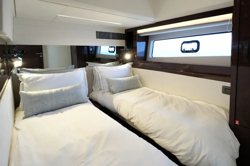 Slide: The Image of Luxurious twin cabin interior on 2023 Prestige 590 yacht, featuring elegant bedding and modern design. - 73
