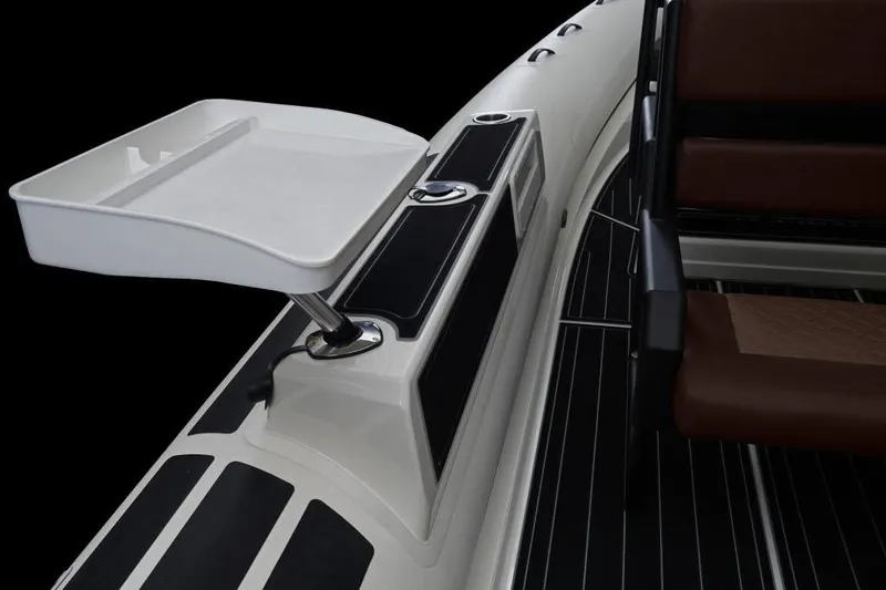 Slide: The Image of 2027 Brig Navigator 24 boat interior with seating and utility tray. - 2