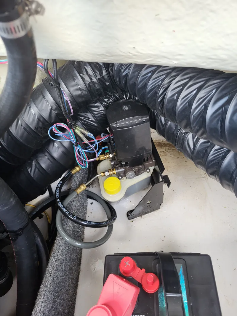 Slide: The Image of Close-up of a boat's engine compartment with hoses and a battery. - 26