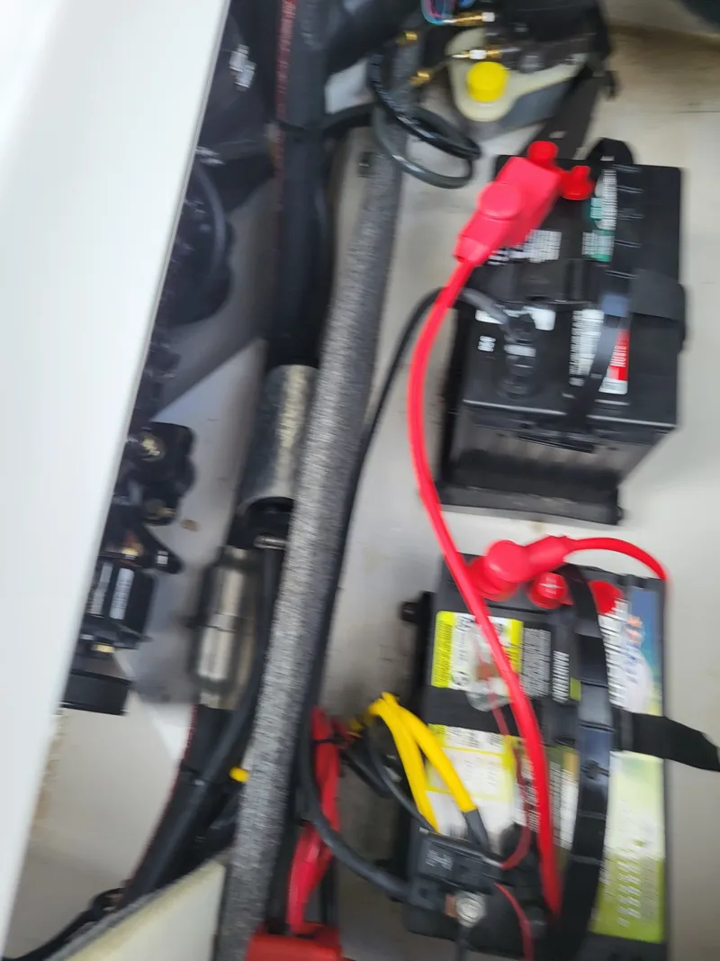 Slide: The Image of Batteries and wiring in the engine compartment of a 2014 Glastron GT 229 boat. - 24