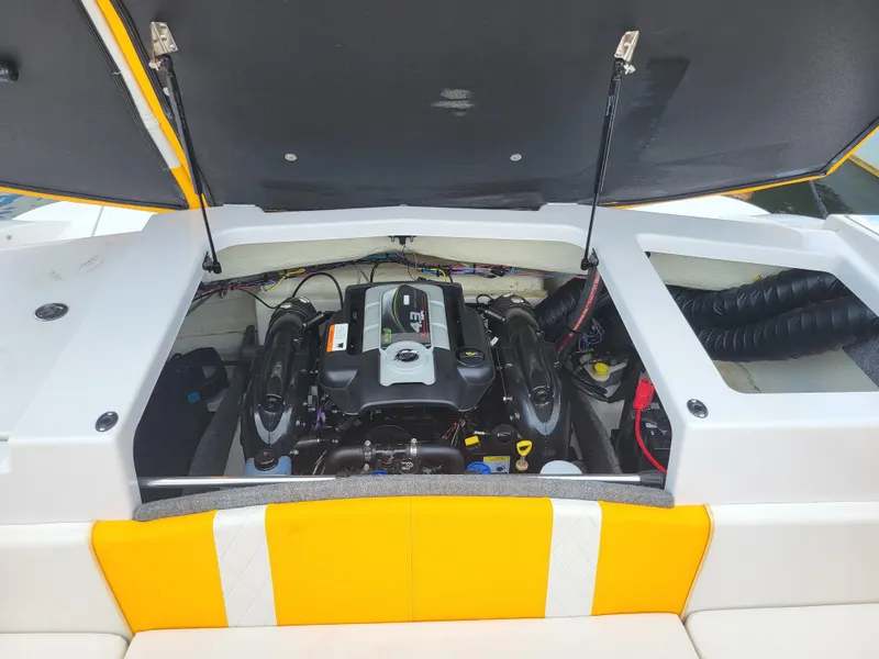 Slide: The Image of The engine compartment of a 2014 Glastron GT 229 is open, revealing the engine and wiring. - 28