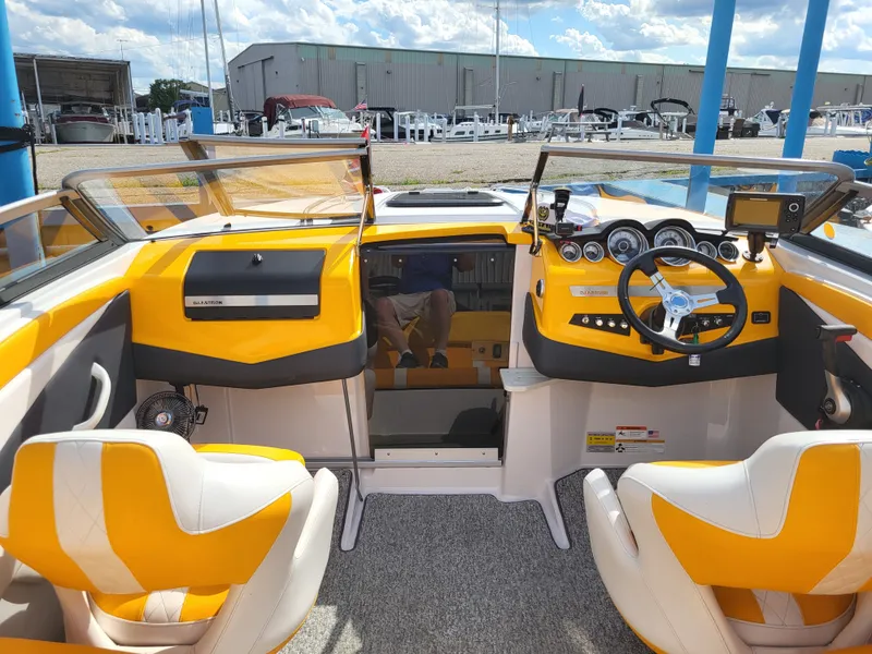 Slide: The Image of The image shows the cockpit of a 2014 Glastron GT 229 boat with yellow and white seats. - 5