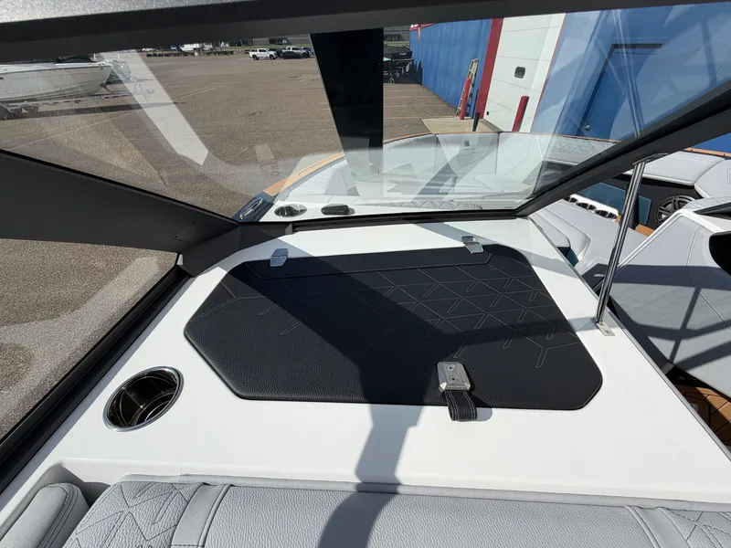 Slide: The Image of The image shows the cockpit of a 2027 Nautique S25 Super Air. It features a modern design with a black dashboard and a cup holder. - 34