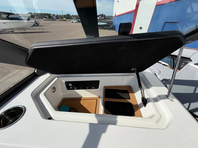 Slide: The Image of The image shows an open storage compartment on a 2027 Nautique S25 Super Air boat. - 39
