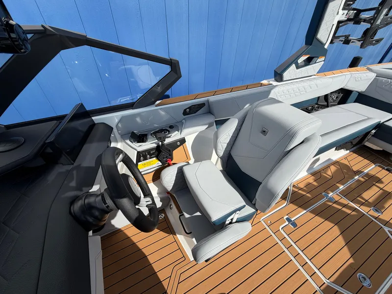 Slide: The Image of The image shows the cockpit of a 2027 Nautique S25 Super Air with modern seating and wood flooring. - 35