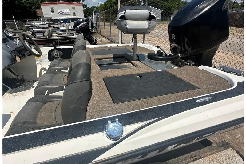 Slide: The Image of A 2012 Nitro Z-7 boat with multiple seats and an outboard motor, parked in a yard. - 5