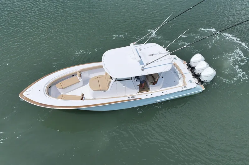 Slide: The Image of 2023 Phenom 34 boat cruising on water with triple outboard engines. - 11
