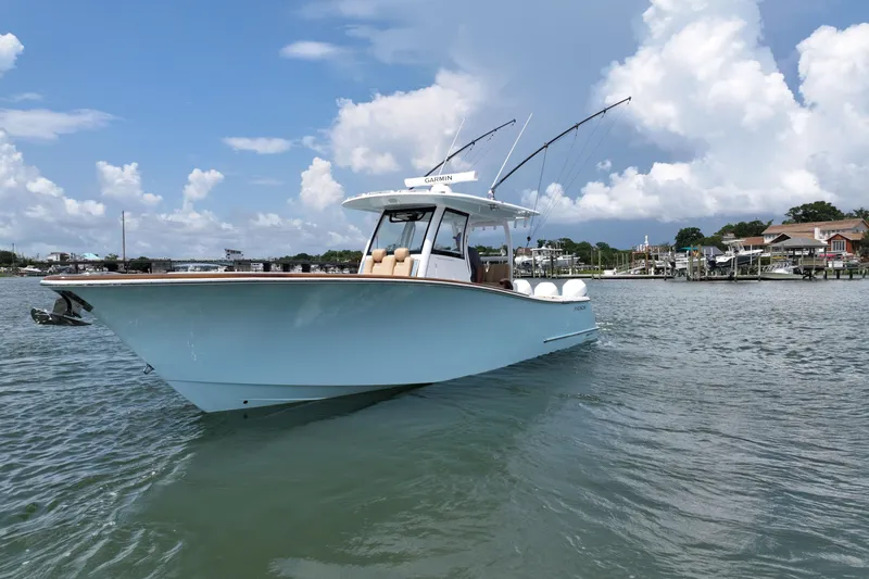 Slide: The Image of 2023 Phenom 34 boat on calm water under a partly cloudy sky. - 2