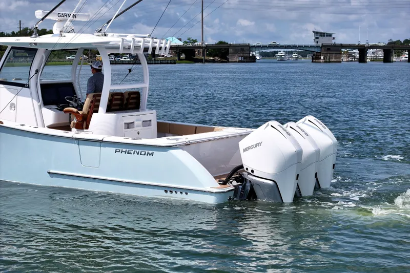 Slide: The Image of 2023 Phenom 34 boat with triple Mercury engines cruising on a sunny day. - 4
