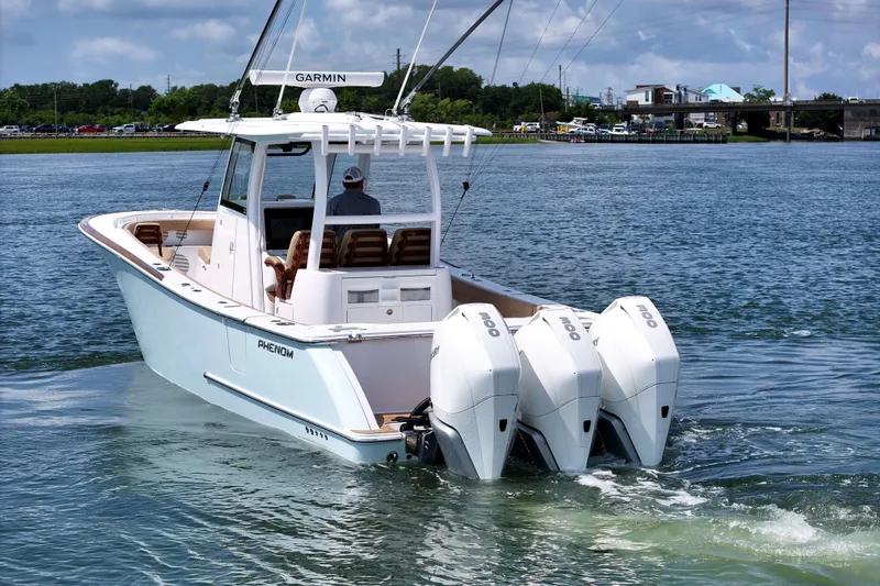 Slide: The Image of 2023 Phenom 34 boat with triple outboard engines cruising on a sunny day. - 5