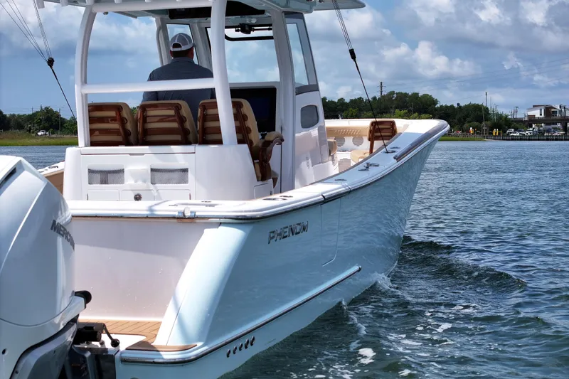Slide: The Image of 2023 Phenom 34 boat cruising on water with Mercury engine, clear sky background. - 16